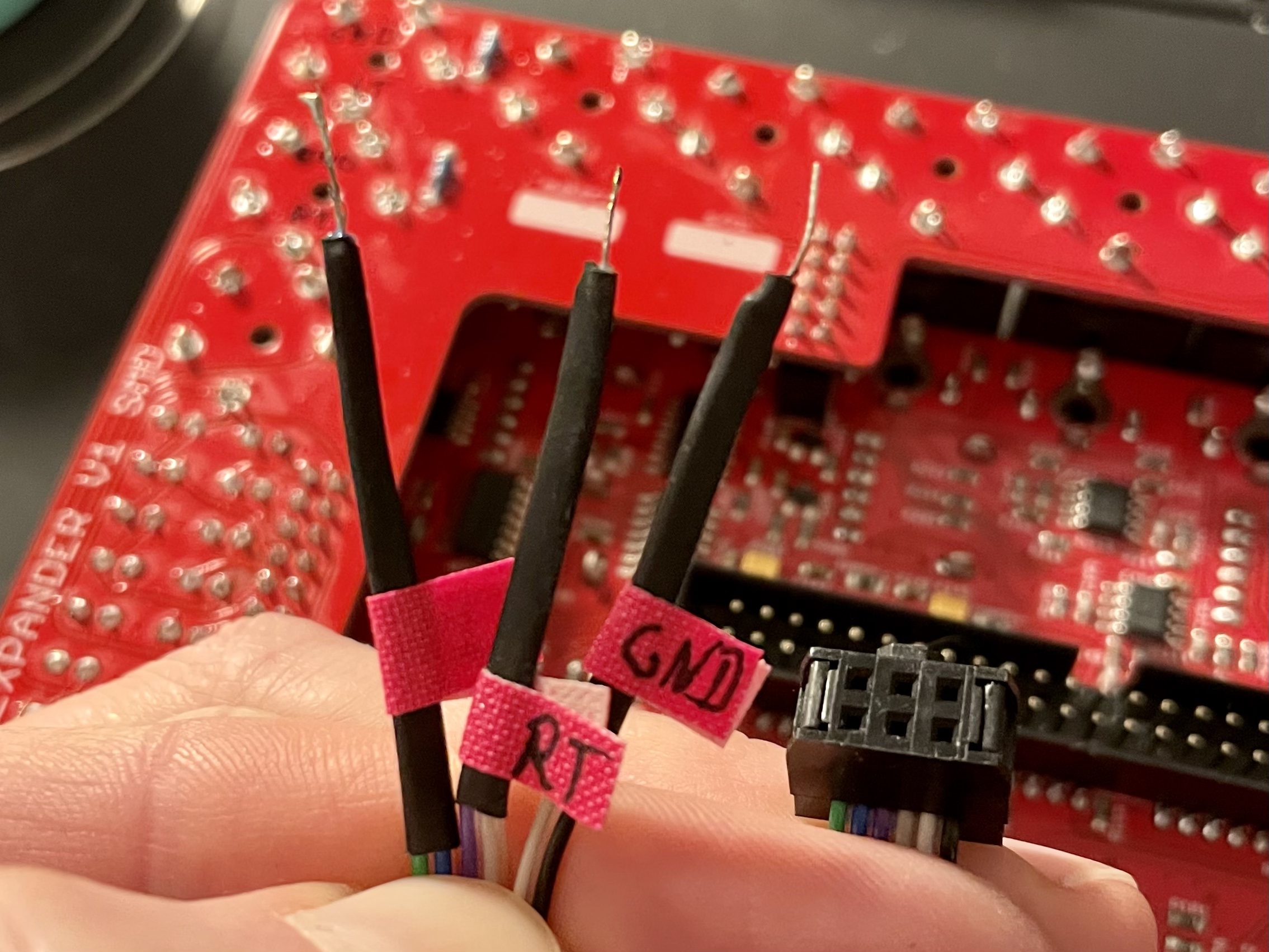 The prepared ribbon cable with labels attached to the loose ends to determine ground, left and right tip